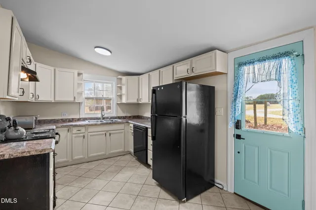 a kitchen with granite countertop white cabinets and a sink