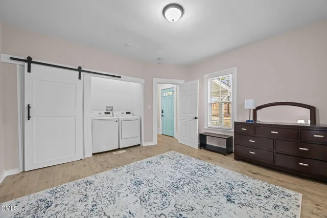 a view of a bedroom with a bed and wooden floor