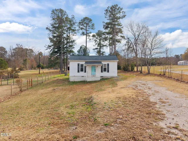 a view of a house with backyard and trees