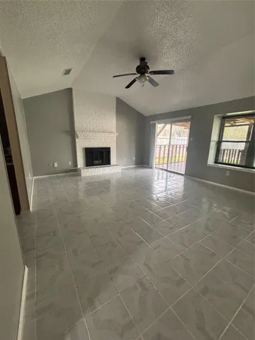 a view of an empty room with a fireplace and a window