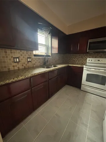 a kitchen with a sink stove and cabinets