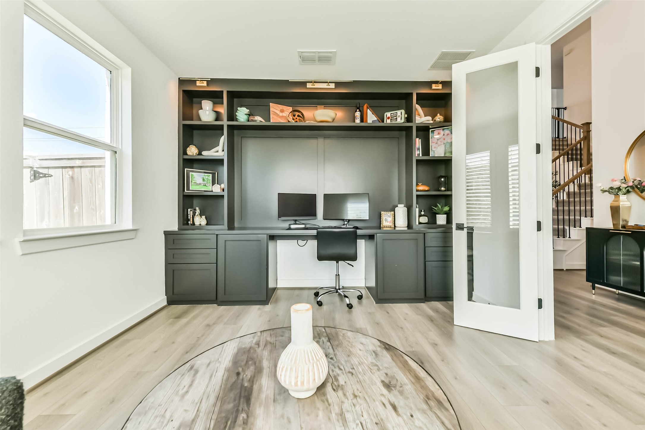 1612 Dayton Rdg Circle Friendswood, TX 77546 - Photo 19 of 50 home office with built-in shelving and desk, featuring sleek black cabinetry, large window for natural light, and elegant glass French doors.