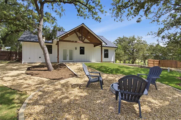 a view of a house with backyard and a tree