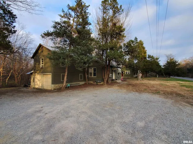 a view of a house with backyard and trees