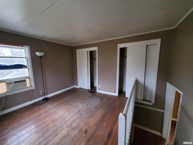 an empty room with wooden floor and a window