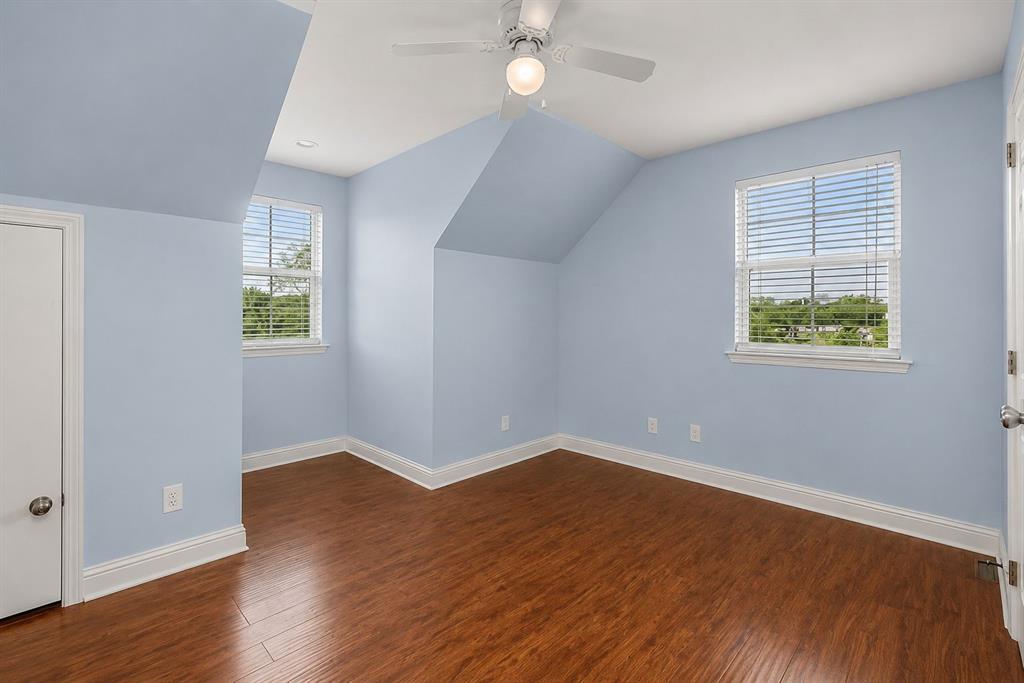 179 Ranchtown Road Elm Grove, LA 71051 - Photo 10 of 26 Room featuring wood-finish flooring, two windows with white blinds, and a ceiling fan with light fixture