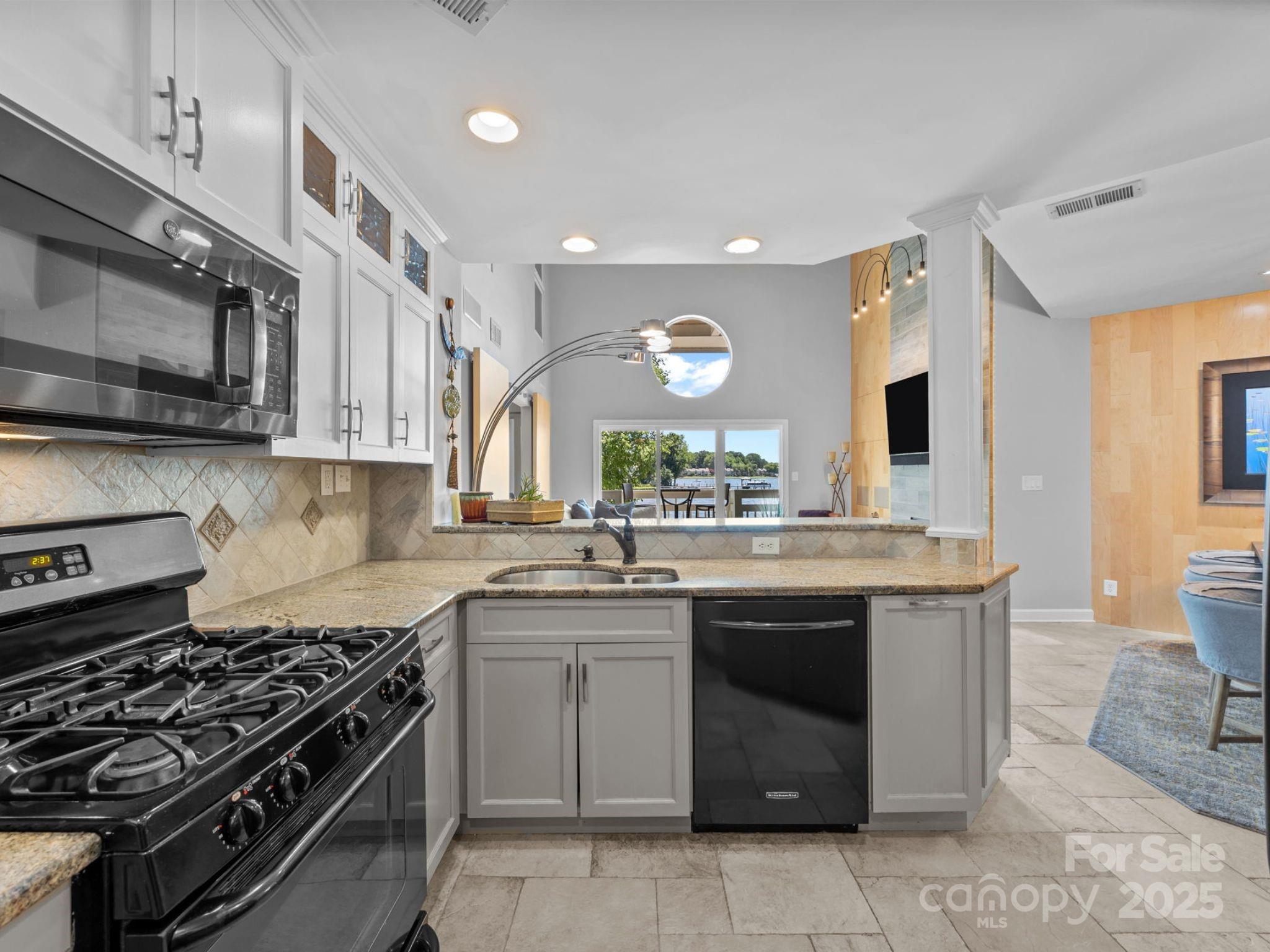 17925 Kings Point Drive, Unit F Cornelius, NC 28031 - Photo 12 of 35 a kitchen with stainless steel appliances a sink stove and cabinets