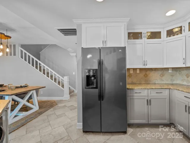 a kitchen with stainless steel appliances granite countertop a refrigerator and a stove