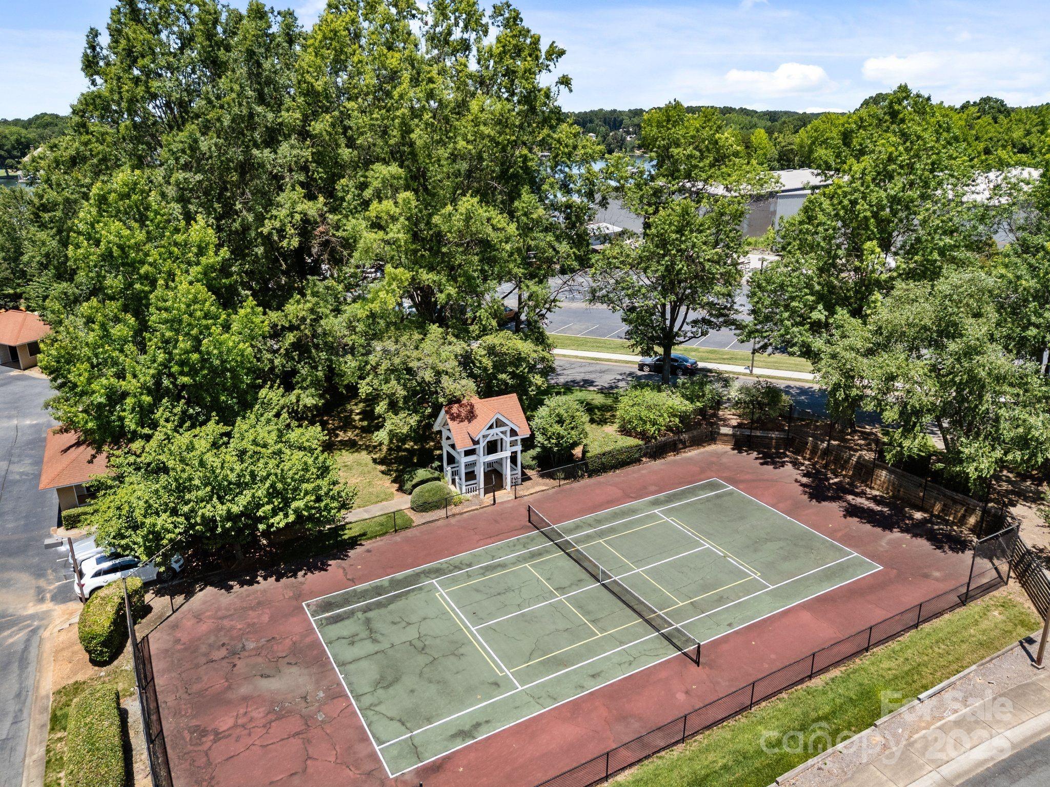 17925 Kings Point Drive, Unit F Cornelius, NC 28031 - Photo 34 of 35 a view of a tennis ground with large trees