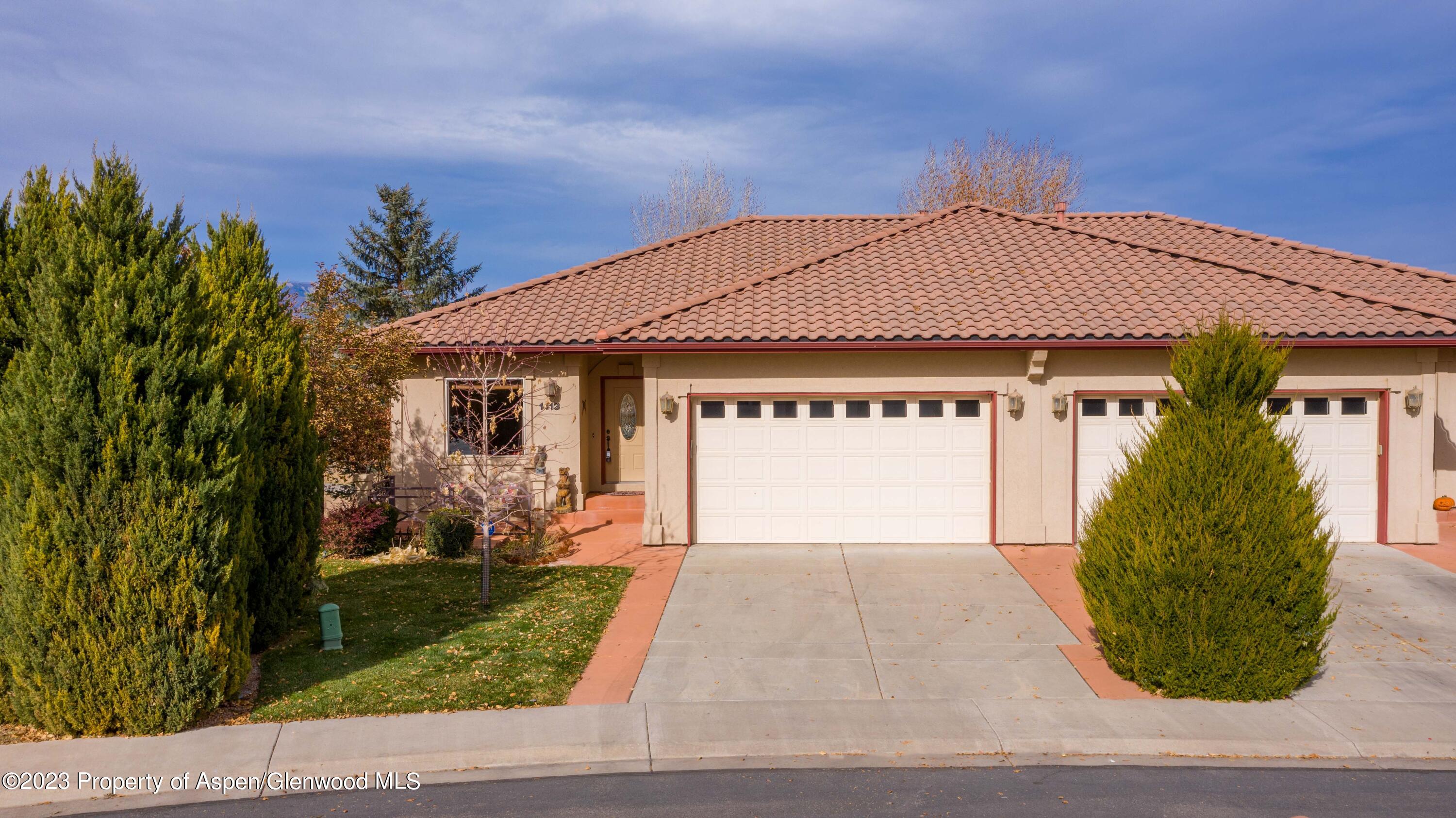 1413 Fir Court Rifle, CO 81650 - Photo 1 of 23 a front view of a house with a garden and trees