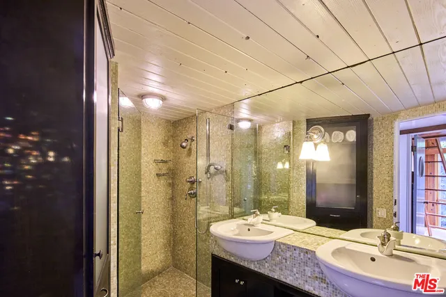 a bathroom with a granite countertop sink a toilet a mirror and shower