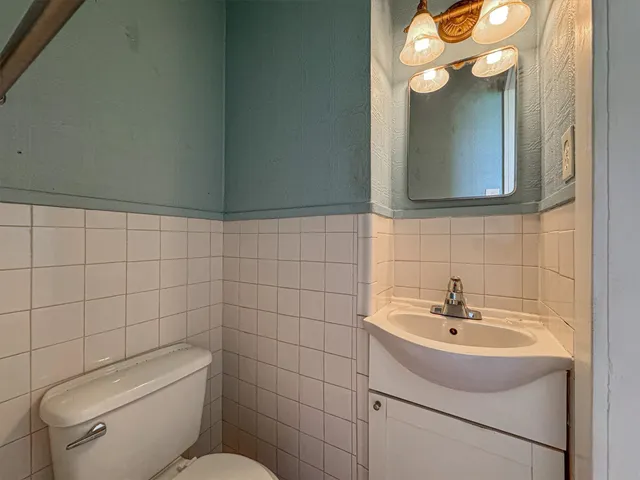 a bathroom with a sink a toilet and mirror