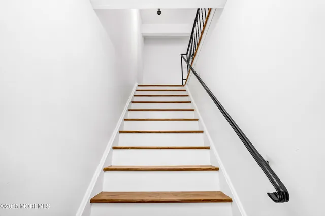 an empty room with wooden floor closet and windows
