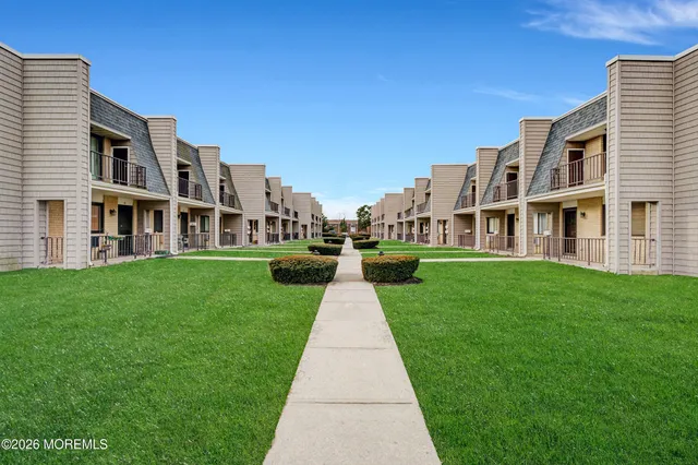 front view of a brick house with a yard
