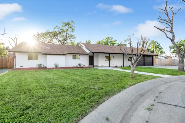 a front view of a house with a garden and yard