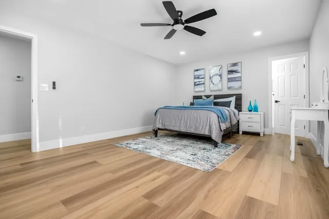 a living room with a bed furniture and a wooden floor