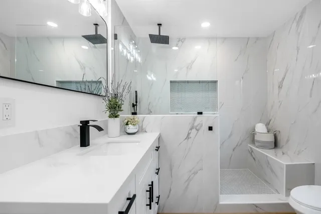 a bathroom with a sink a toilet and shower