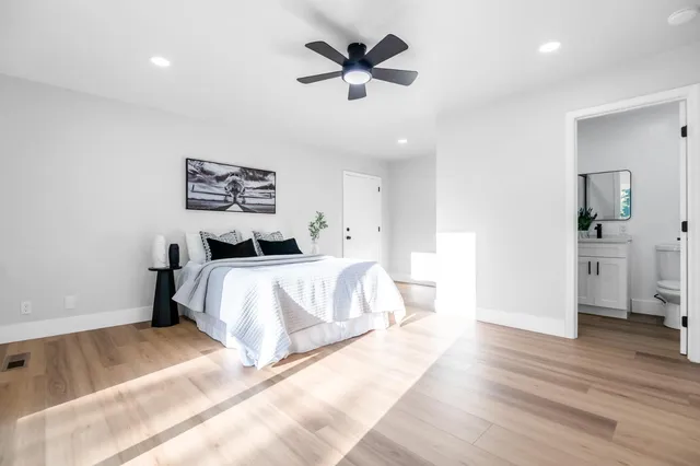 a bedroom with a bed and a ceiling fan