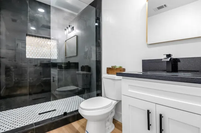 a bathroom with a toilet sink and mirror