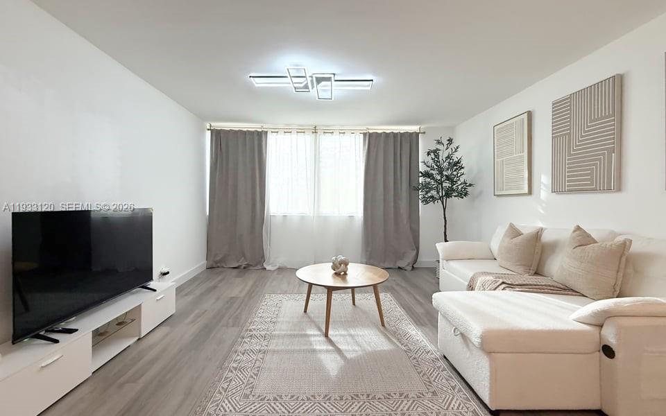 9125 Southwest 77th Avenue, Unit 307 Miami, FL 33156 - Photo 11 of 21 a living room with furniture a flat screen tv and a window