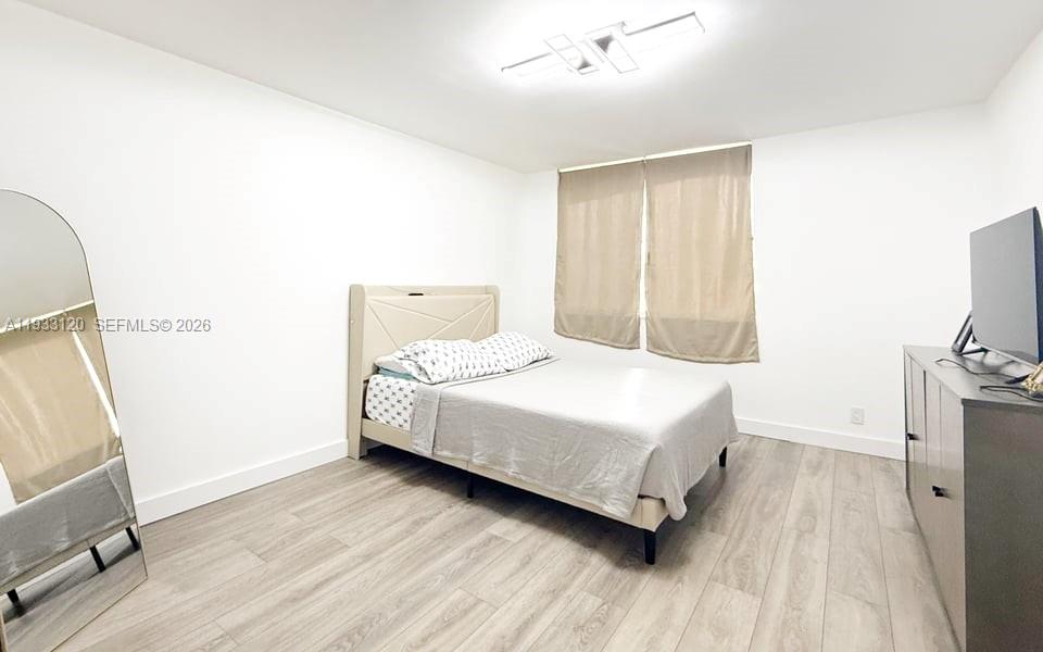 9125 Southwest 77th Avenue, Unit 307 Miami, FL 33156 - Photo 12 of 21 a bedroom with a bed and wooden floor