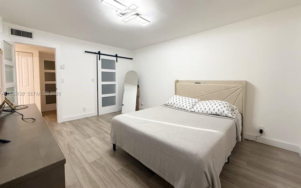 9125 Southwest 77th Avenue, Unit 307 Miami, FL 33156 - Photo 13 of 21 a large bed sitting in a bedroom next to a window and dresser