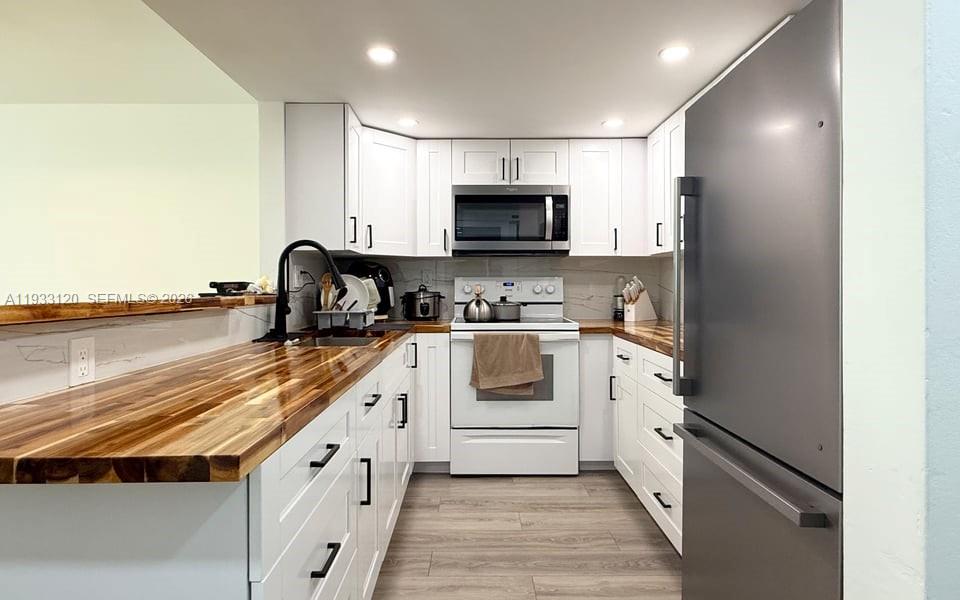 9125 Southwest 77th Avenue, Unit 307 Miami, FL 33156 - Photo 19 of 21 a kitchen with granite countertop a sink a stove and cabinets