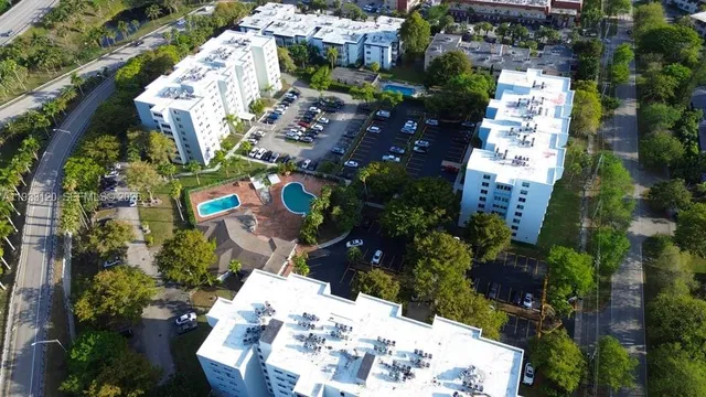a aerial view of a house with a swimming pool and large trees