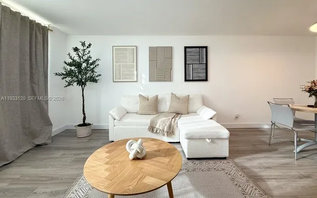 a living room with furniture a flat screen tv and a window