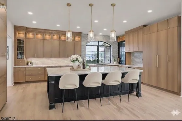 a kitchen with a dining table chairs and white cabinets