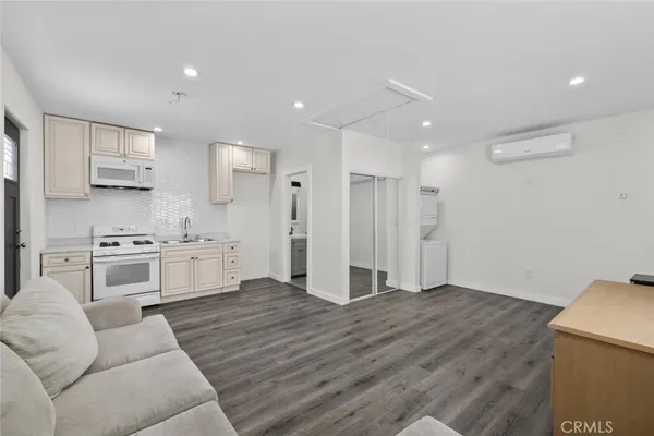 a kitchen with stainless steel appliances white cabinets and wooden floor