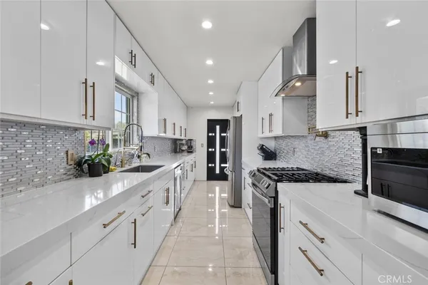 a large kitchen with stainless steel appliances granite countertop a sink and cabinets