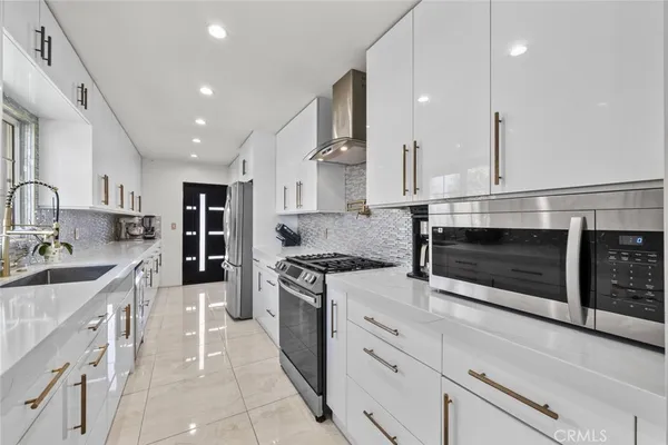 a kitchen with stainless steel appliances granite countertop a stove a sink and a microwave