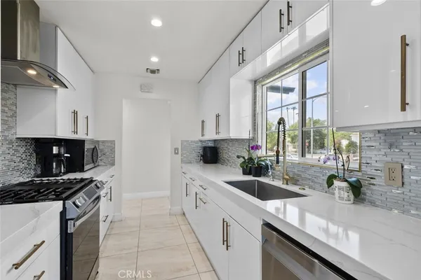 a kitchen with a sink a stove and cabinets