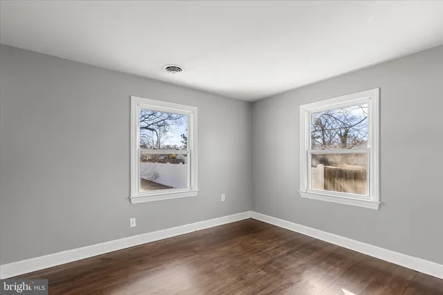 a view of a big room with wooden floor and window