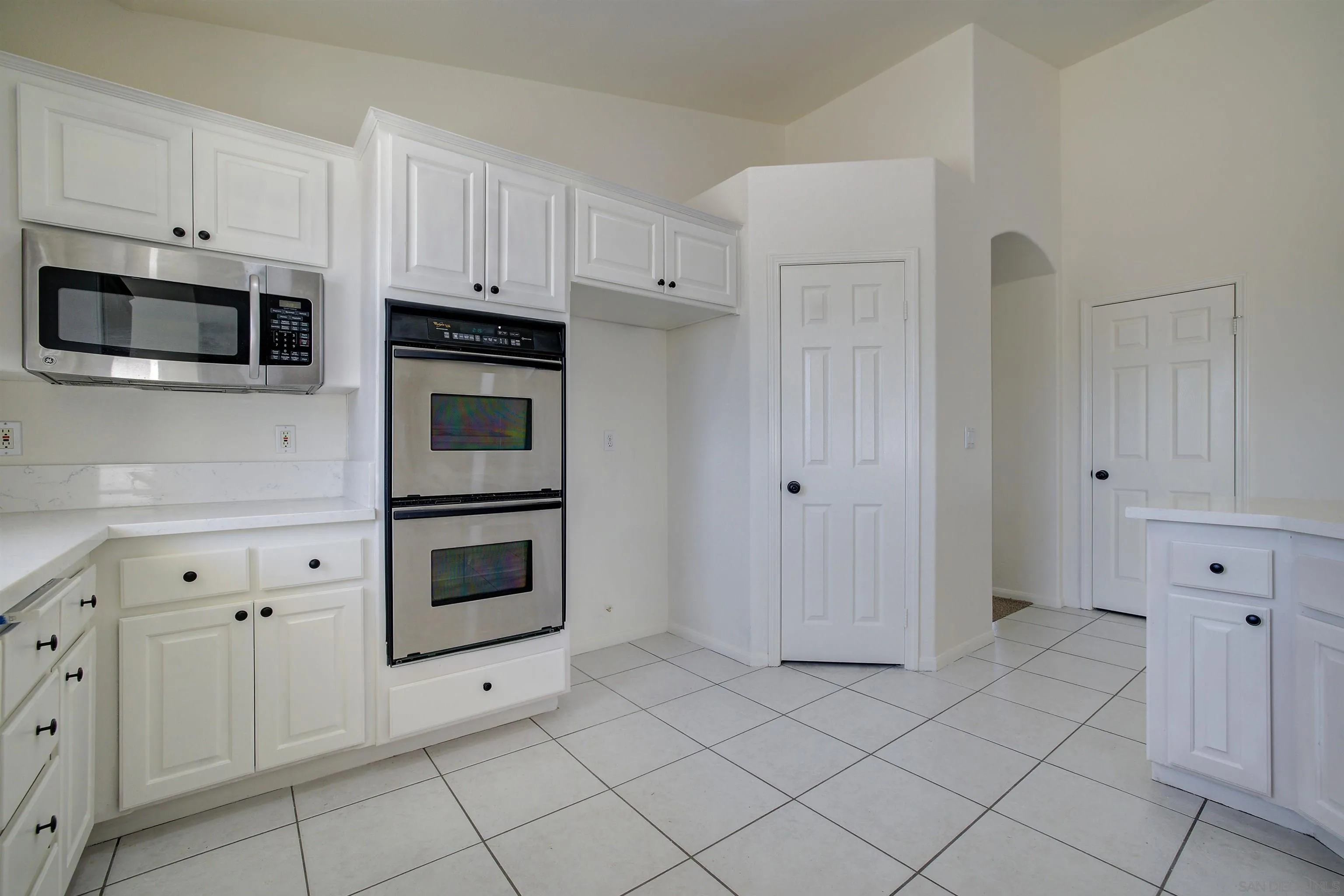 31250 Rivoli Road Valley Center, CA 92082 - Photo 20 of 57 a kitchen with white cabinets and appliances