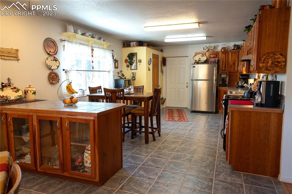 3370 Schieffelin Road Fort Garland, CO 81133 - Photo 6 of 46 a dining hall with stainless steel appliances granite countertop a refrigerator and a wooden cabinets