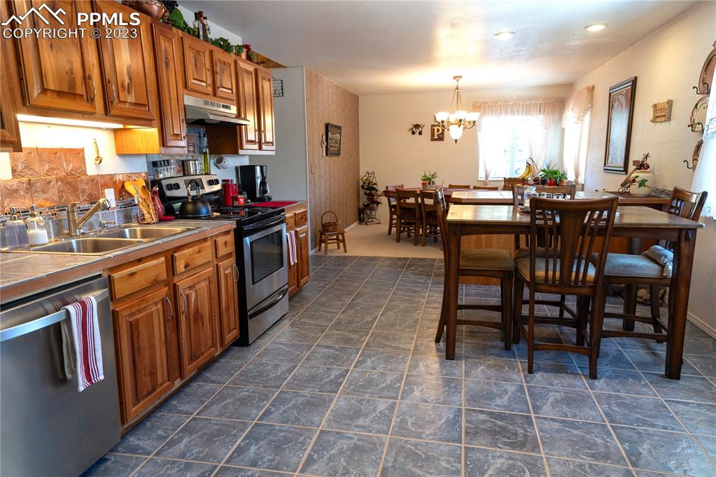 3370 Schieffelin Road Fort Garland, CO 81133 - Photo 8 of 46 a kitchen with stainless steel appliances a sink a counter top space and a view of living room