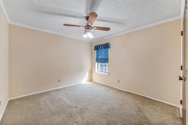 an empty room with a window and a fan