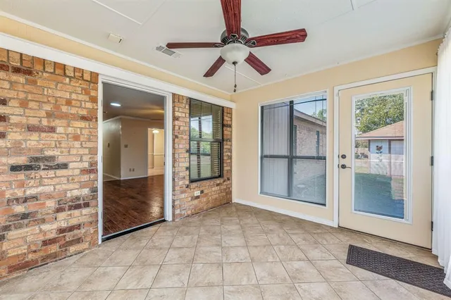 a view of empty room with window and chandelier
