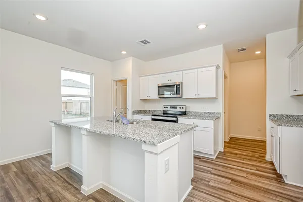 a kitchen with stainless steel appliances granite countertop a stove a sink and a refrigerator