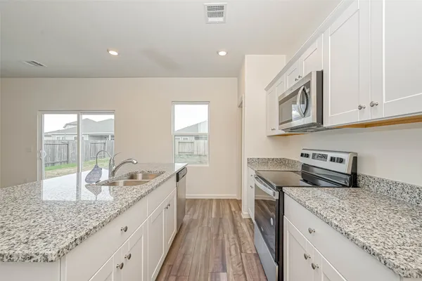 a hallway with kitchen island granite countertop wooden floor and wide window