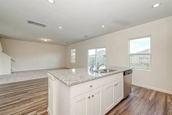 a kitchen with granite countertop cabinets stainless steel appliances and a sink