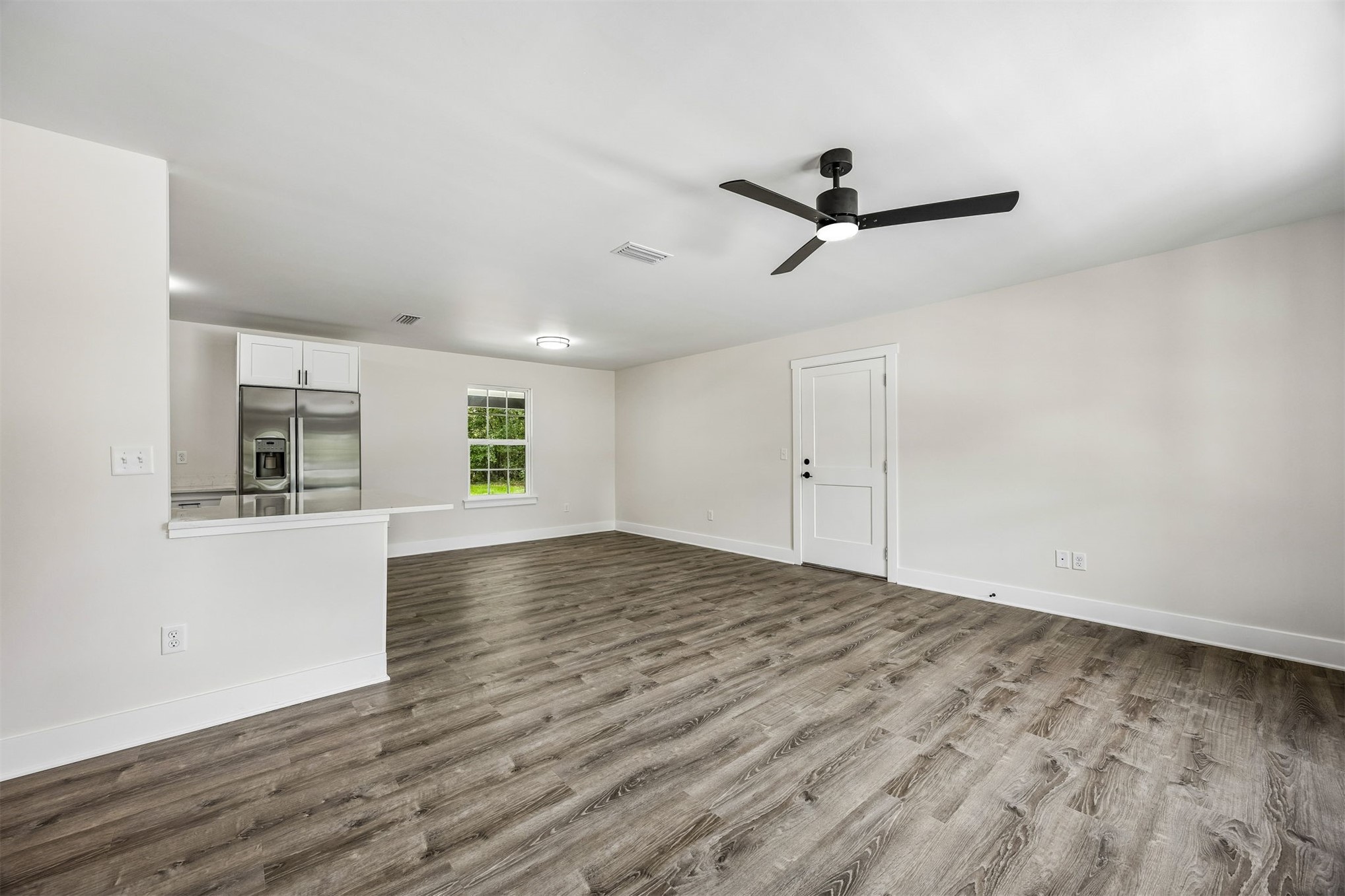 552 Sunset Road Fernandina Beach, FL 32034 - Photo 2 of 23 a view of empty room with wooden floor and ceiling fan