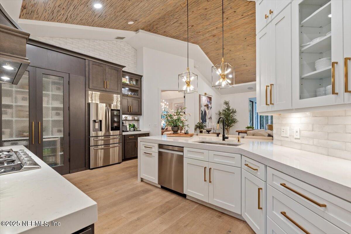 4009 Sioux Circle St. Johns, FL 32259 - Photo 20 of 49 a kitchen with stainless steel appliances kitchen island granite countertop a refrigerator a sink dishwasher a stove and white cabinets with wooden floor