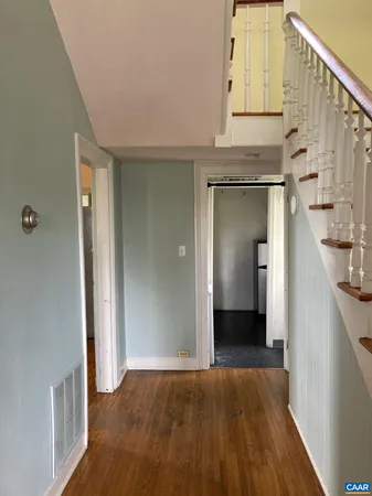 a view of a hallway with wooden floor and staircase