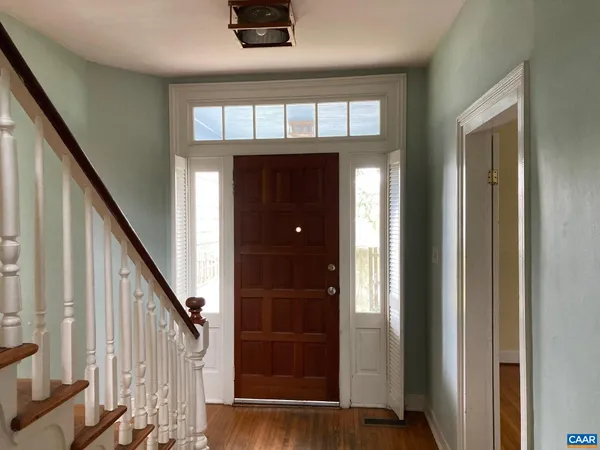 a view of a hallway with wooden floor and staircase