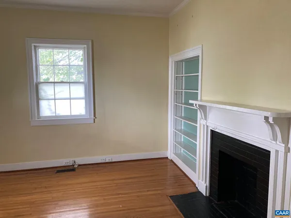 an empty room with wooden floor and a window
