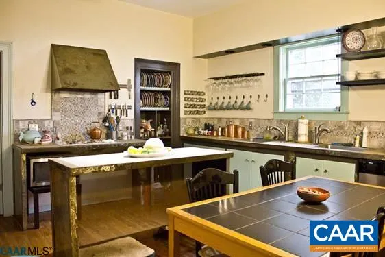 a kitchen with a sink a stove and wooden floor