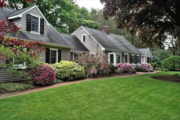 a front view of a house with a yard and trees